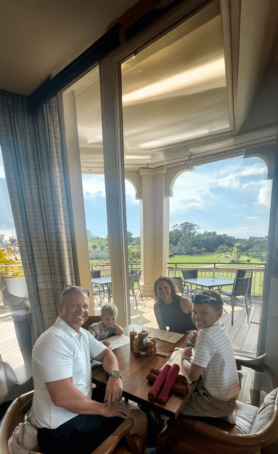 Family enjoying a meal together overlooking a golf course