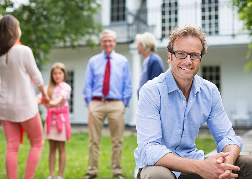 Financial planning client with family members gathered outside a home