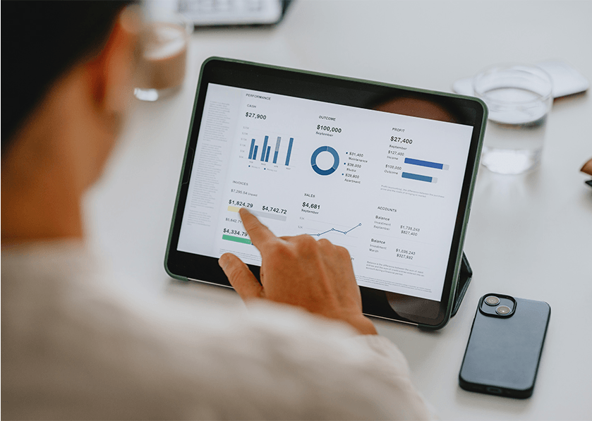 Person reviewing financial performance data and charts on a tablet