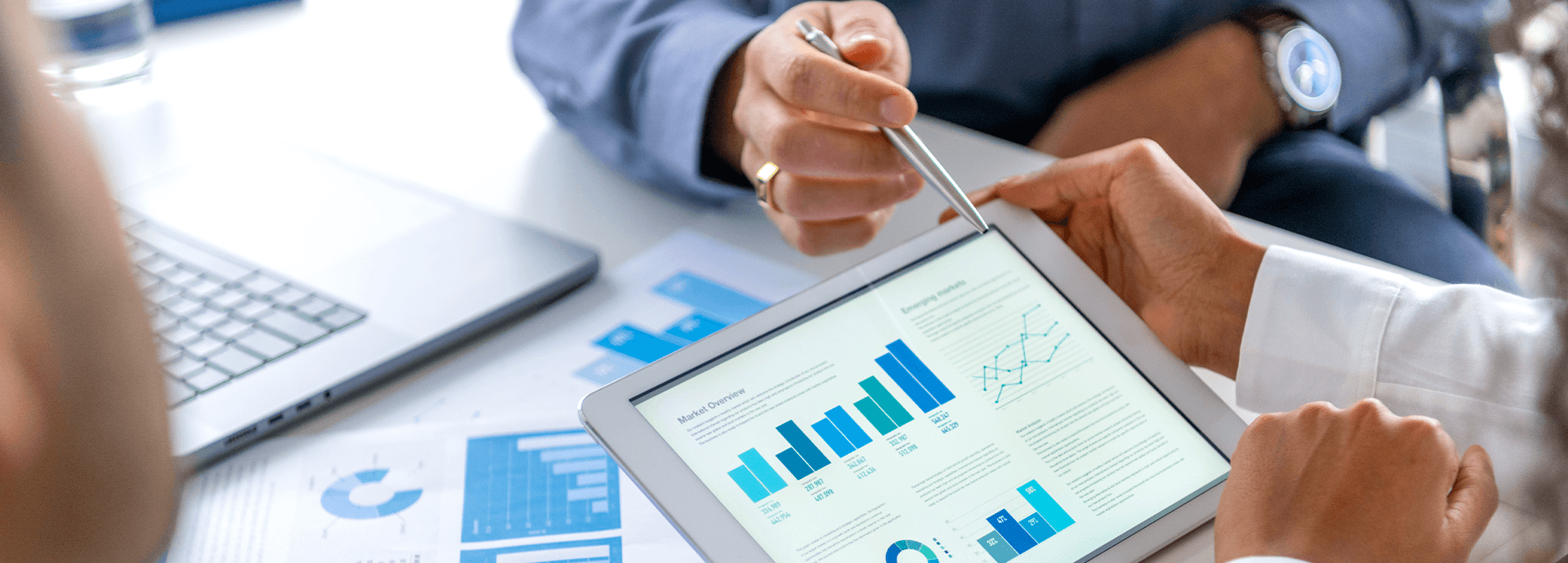 Financial professionals reviewing investment performance and market data on a tablet